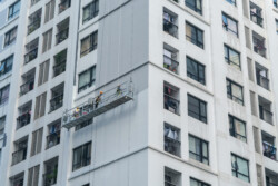 Apartment building with a group of worker painting building exterior